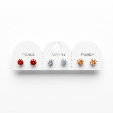 Three pairs of round solitaire stud earrings in red, clear and champagne