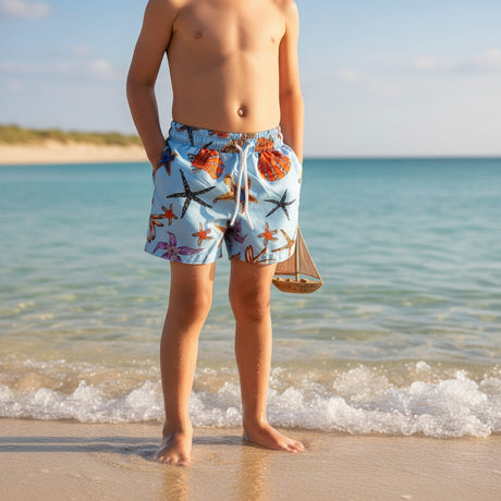 Boy wearing colourful starfish and shell print swim shorts on the beach – Jack Gifts Online Lebanon