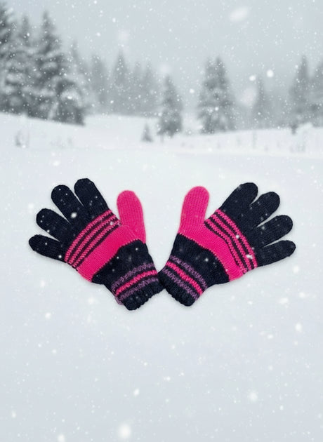 Black and hot pink striped kids gloves in a snowy forest