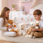 Two children cuddling curly bears dressed in white and camel hooded tracksuits