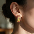 Coral and lime flower enamel huggie hoop earring with tiny crystals worn on the ear