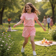 Girl in coral Enjooy print tee and matching shorts set outdoors, Jack Gifts Online Lebanon