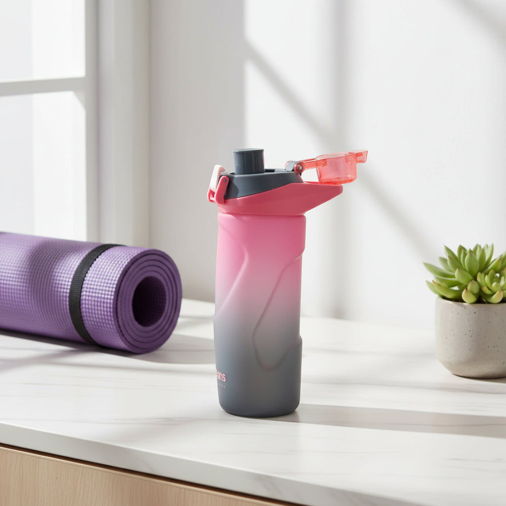 Coral to charcoal ombre water bottle showing the moulded side carry loop and lid catch