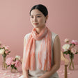 Woman wearing a pink coral scarf in a soft pink background