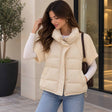 Woman in a cream quilted puffer jacket with short cable knit sleeves over a white long sleeve top