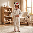Child in a cream fluffy hooded onesie with black ears and a red heart on the hood
