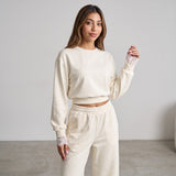 Model touching her chest, lace edging visible at the cream cuff