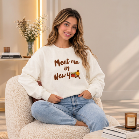 Cream sweatshirt with fluffy brown Meet me in New York lettering and small pumpkin embroidery