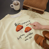 Cream mushroom sweatshirt worn with black leggings and a knit scarf outdoors
