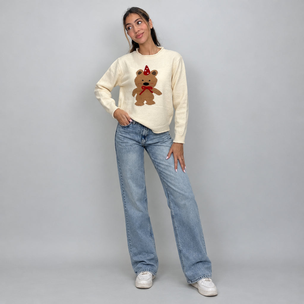 Cream party bear sweater with ribbed cuffs and hem, hand on hip with jeans
