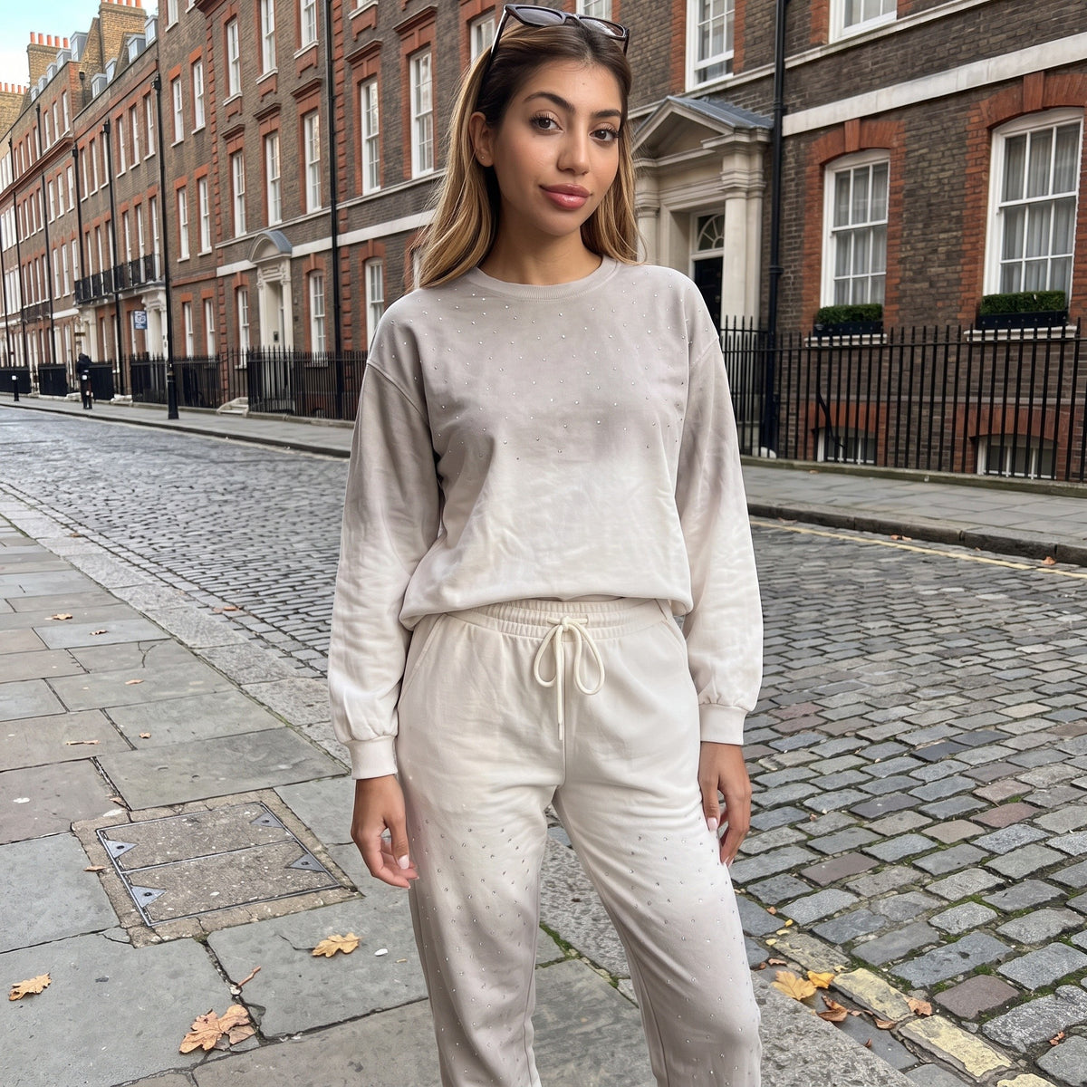 Close view of the crystal studs scattered across the cream sweatshirt and joggers