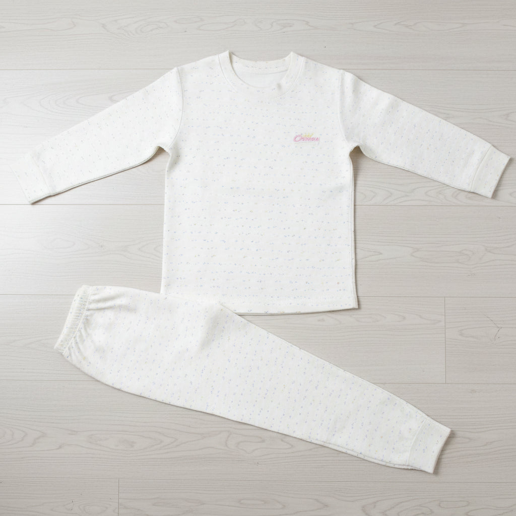 Cream speckled kids sweatshirt pyjama set laid flat on a wood floor, crew neck top with joggers