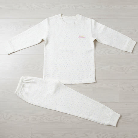 Cream speckled kids sweatshirt pyjama set laid flat on a wood floor, crew neck top with joggers