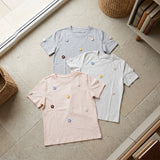 Three crochet flower applique t-shirts in grey, cream and blush pink laid flat