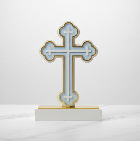 The same trefoil tipped cross in pale blue, its base capped with a gold strip