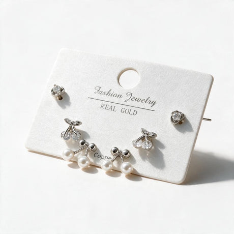 Silver tone stud set with round crystals, crystal cherries and bows with faux pearl drops
