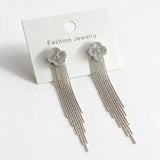 Silver tone crystal clover studs with bead chain fringe on a cream card