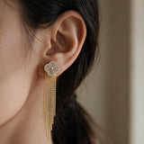 Gold crystal clover stud with long bead chain tassel worn on the ear