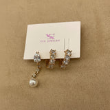 Set of crystal & pearl earrings on a jewelry card with a beige background