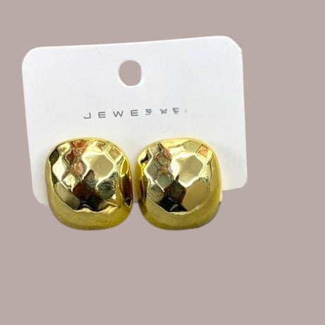 Gold cube earrings on a card with a plain background