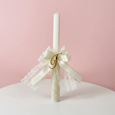 Candle with a gold lace bow, glitter wrapped base and gold letter