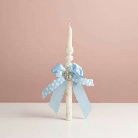 Twisted candle with a blue cloud print bow and gold letter