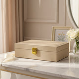 Champagne velvet jewelry box closed on a marble console beside white roses