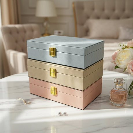 Pale blue, champagne and blush pink velvet jewelry boxes stacked with gold flip clasps