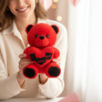 Woman holding a small bright red bear that hugs a heart reading I love you