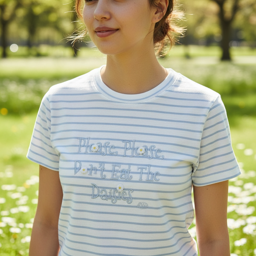 Woman in the blue striped daisy tee standing in a park