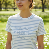 Woman in the blue striped daisy tee standing in a park