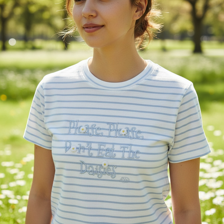 Woman in the blue striped daisy tee standing in a park