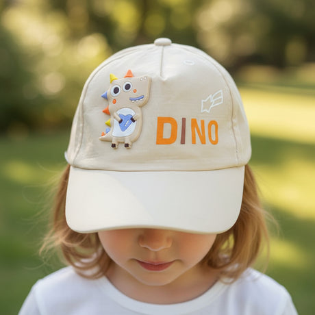 Cream coloured kids cap with an orange DINO print and a raised dinosaur patch, worn by a child