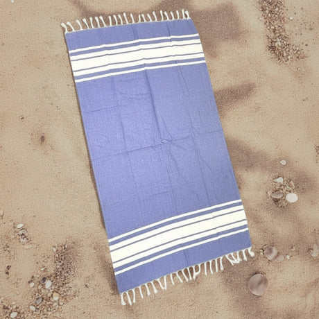 Blue towel with white stripes on a sandy background