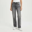 Person wearing dark gray jeans and white sneakers on a plain background