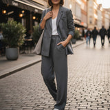 Charcoal grey blazer and joggers worn with a white tee walking a cobbled street