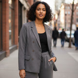 Charcoal grey blazer set worn over a black top on a city street