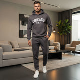 Man wearing a dark grey 'Chicago USA' hoodie and pants in a modern living room
