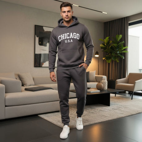 Man wearing a dark grey 'Chicago USA' hoodie and pants in a modern living room