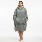 Person wearing a gray hooded blanket on a white background