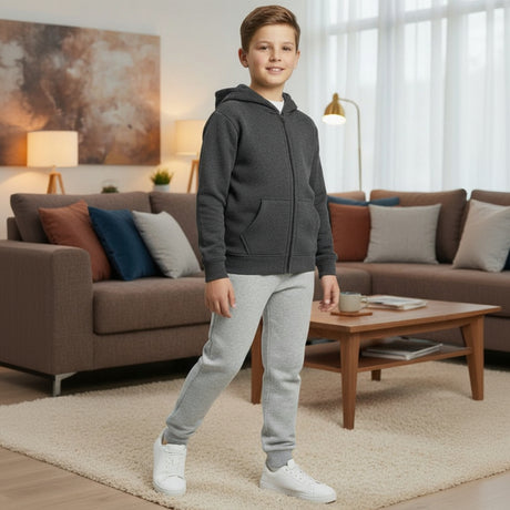Boy wearing a charcoal grey zip up hooded jacket with light grey joggers and white sneakers