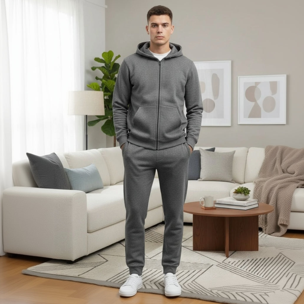 Man wearing a dark grey tracksuit standing in a living room