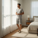 Dark grey pantacour pyjama set worn by a bright bedroom window