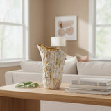 The tall vase standing empty on an oak table with a monstera leaf laid beside it