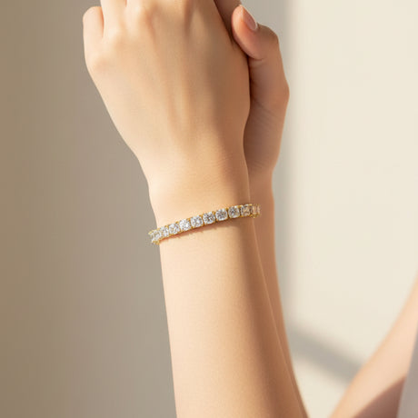 Gold tennis bracelet with diamond accents worn by a person