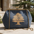 Denim blue clutch with a large gold cedar tree stitched on the front and a gold chain strap