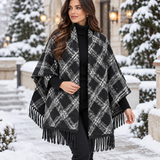 Black and white diamond plaid blanket wrap draped over the shoulders with long black fringe in the snow