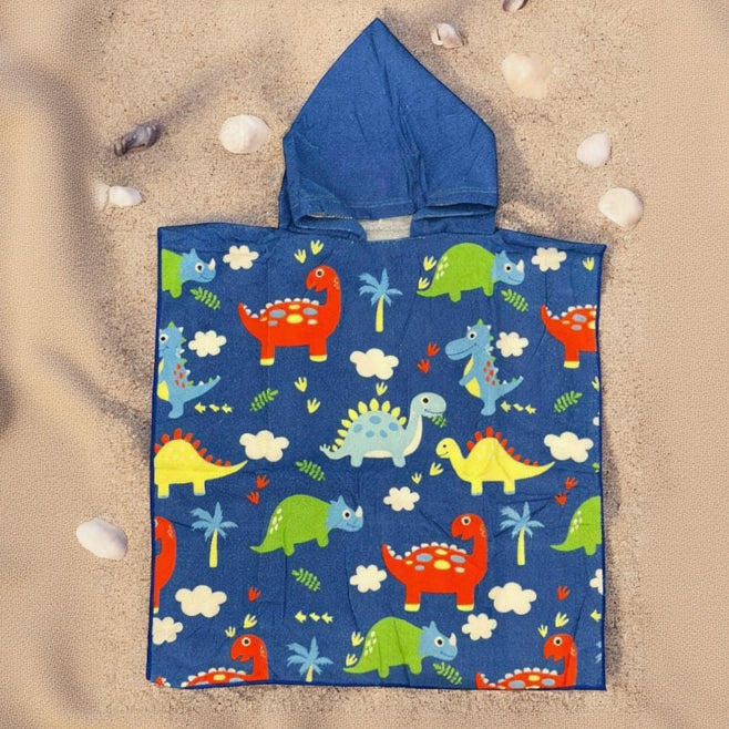 Royal blue poncho towel with an all over dinosaur, palm tree and cloud print flat lay