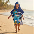 Boy running in a navy and white striped poncho towel with a dinosaur in yellow sunglasses