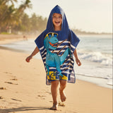Boy running in a navy and white striped poncho towel with a dinosaur in yellow sunglasses